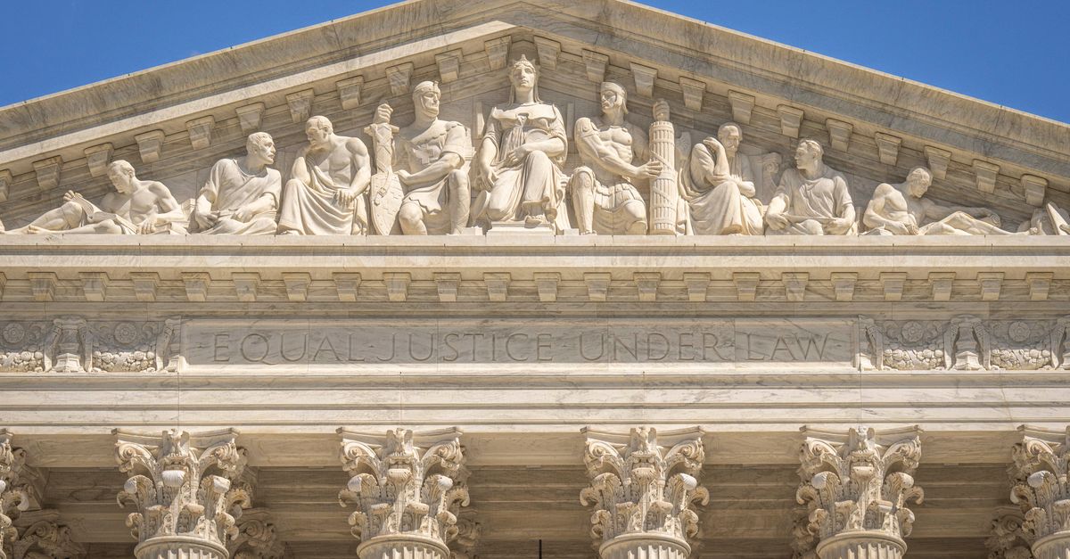 Detailed view of the Supreme Court Building's frontal frieze depicting historical figures and justices.